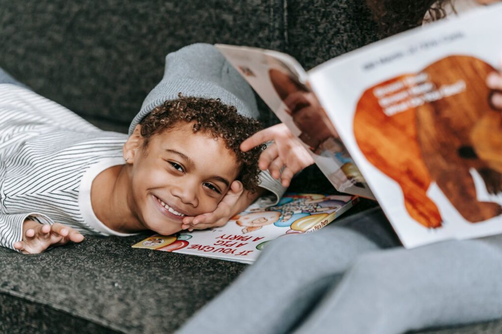 Smiling boy lying down with a picture book