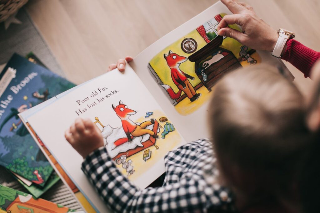 Child turning the pages of an illustrated picture book
