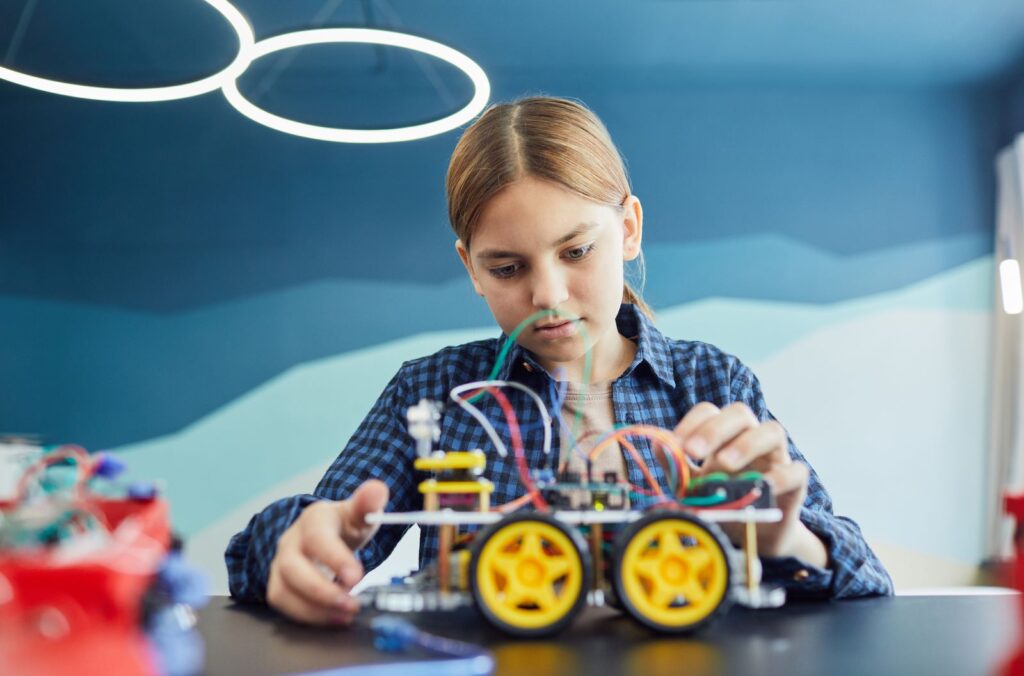 Girl building a small robot car kit