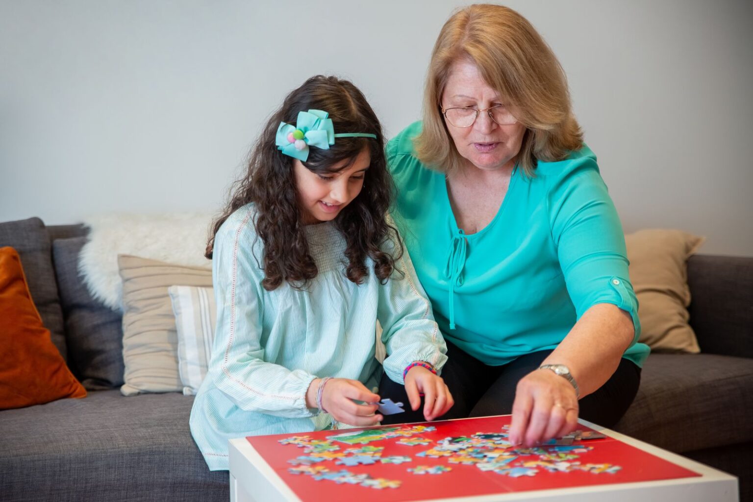 Grandmother and granddaughter doing a colorful jigsaw puzzle together