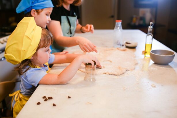 Children in chef hats and aprons rolling dough at a kitchen counter