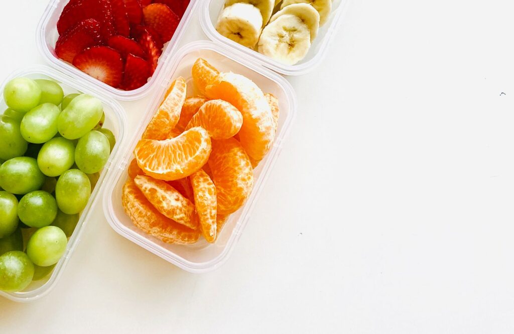 Containers of orange slices, grapes, strawberries and banana