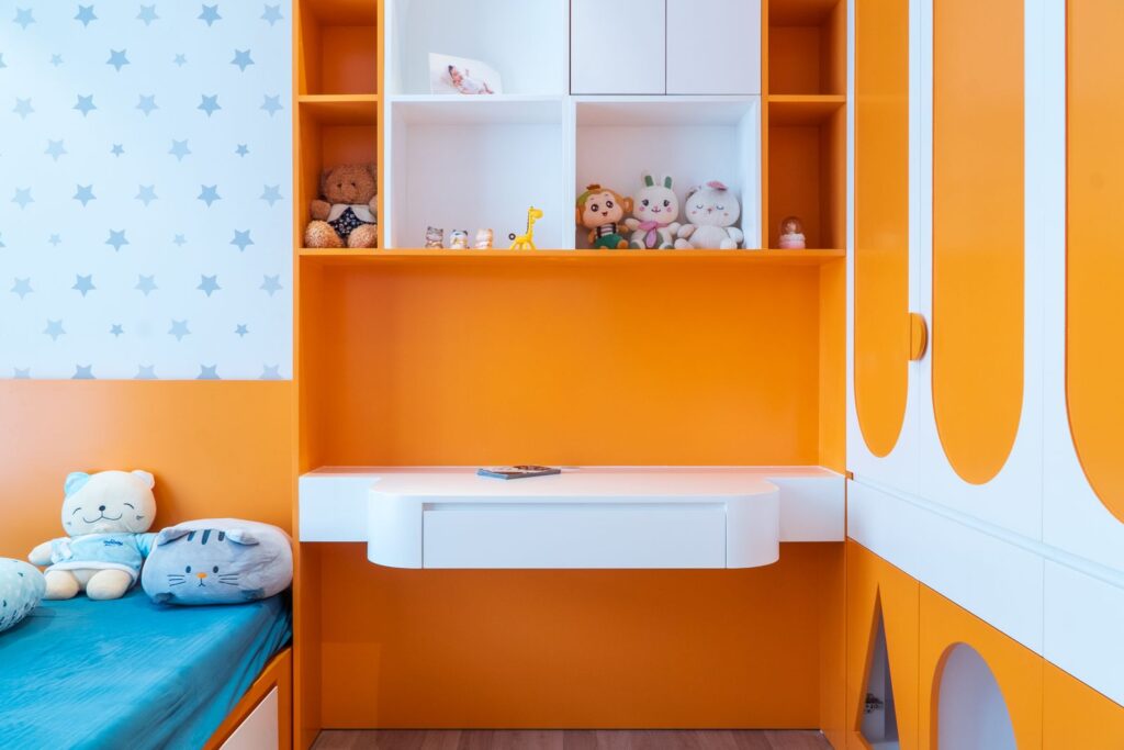 Kids' room with orange built-in shelves and cupboards