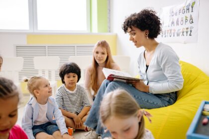 Children listening to a story on a bright yellow beanbag