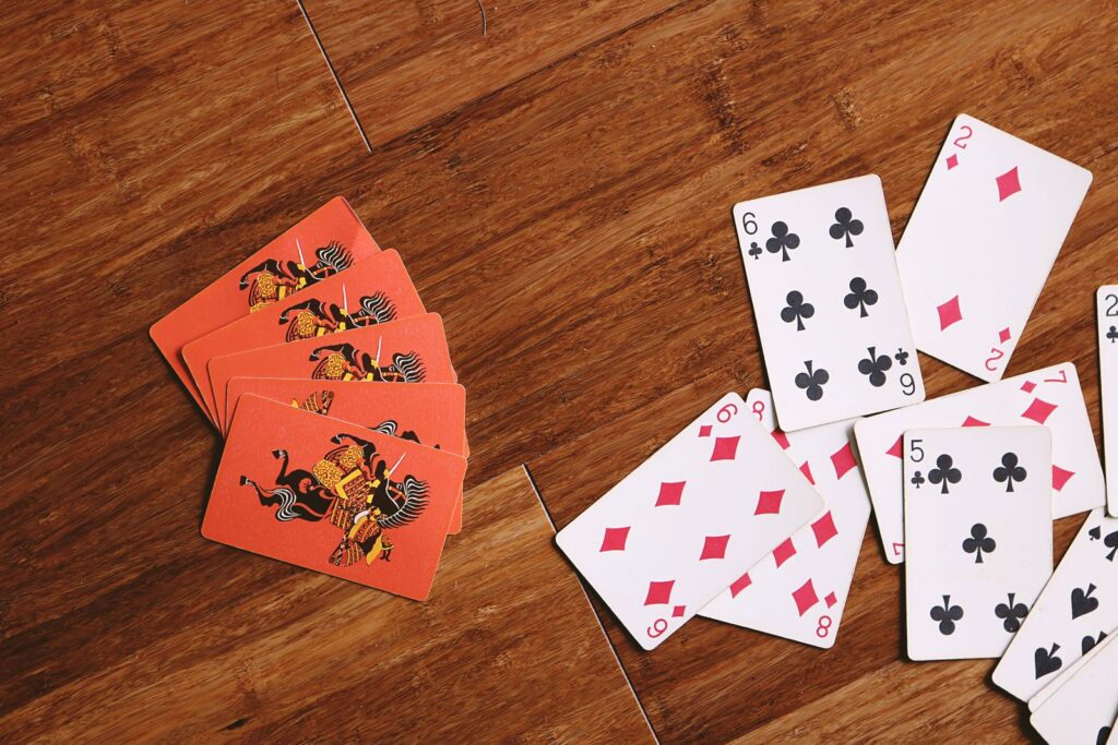 Hand of playing cards spread on a wooden floor