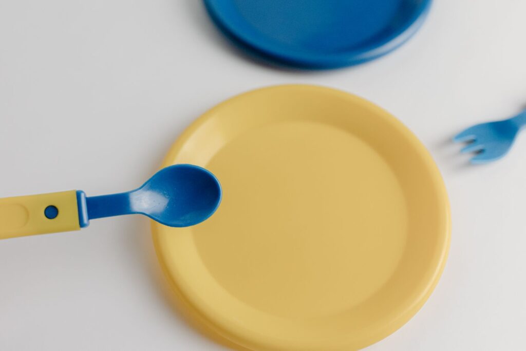 Yellow toddler plate with a blue and yellow toddler spoon